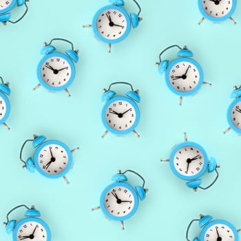 Flat lay retro beautiful new alarm clock on blue color background. Minimal pattern. Top view. Wasting time concept