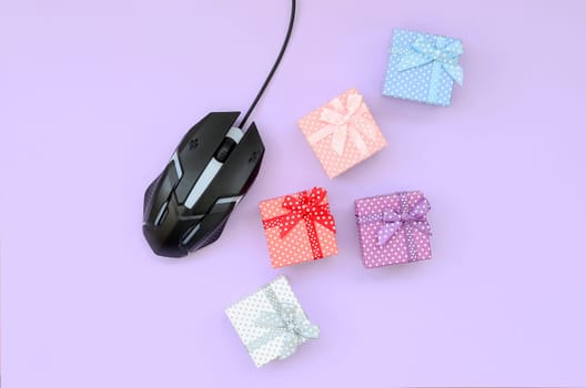 Computer mouse and lots of gift boxes on a purple background. Online shopping concept, internet ordering gifts