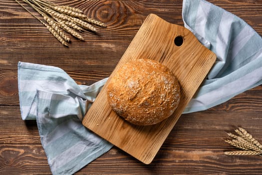Overhead view of homemade wheat bread on wooden cutting board
