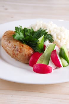 Fried sausage with rice and fresh cucumber and radish