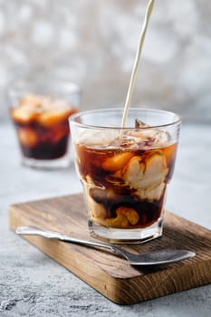 Pouring cream in iced coffee