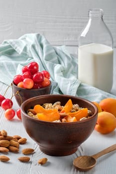 muesli with apricots and almonds on white wooden table