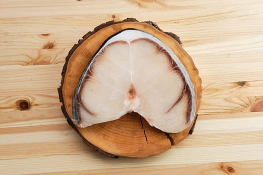 Top view of frozen blue shark steak on wooden table