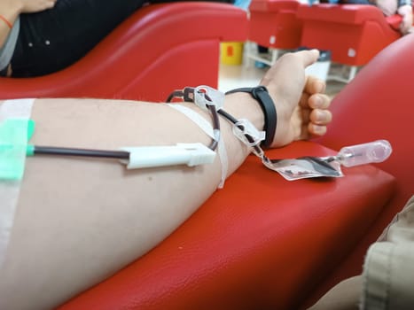 Blood donation, blood transfusion, check specified, fasting, health care. Left arm of caucasian young man with equipment for blood or plasma donations in donation centre. Blood donation concept. Plasma donation concept. Save life concept