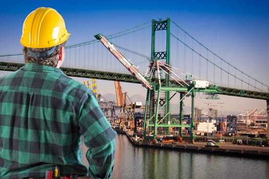 Male Worker Wearing Yellow Hard Hat Overlooking the San Pedro Ship Yard and Bridge.