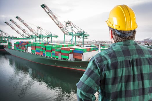 Male Worker Wearing Yellow Hard Hat Overlooking the San Pedro Ship Yard and Bridge.