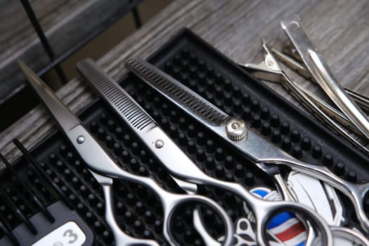 Vintage barber shop tools on old wooden background and rubber mat.