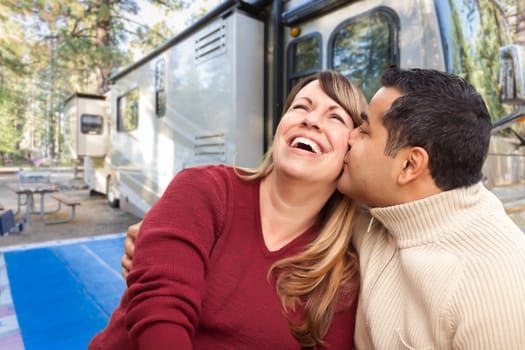 Happy Multiethnic Caucasian and Hispanic Couple In Front of Their Beautiful RV At The Campground.