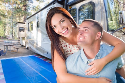 Young Adult Military Couple In Front of Their Beautiful RV At The Campground.