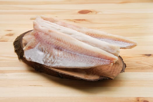 Frozen fillet of pangasius on wooden table