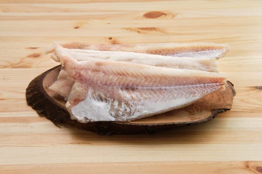 Frozen fillet of pangasius on wooden table