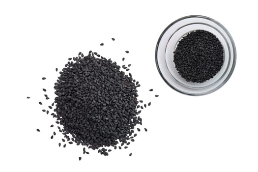 Top view of black sesame seeds in a little bowl and spilled on white background