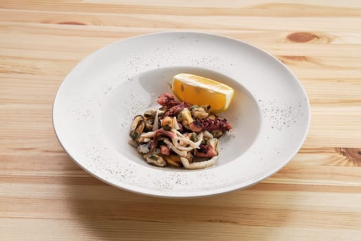 Salad with octopus, shrimps and mussels on wooden table