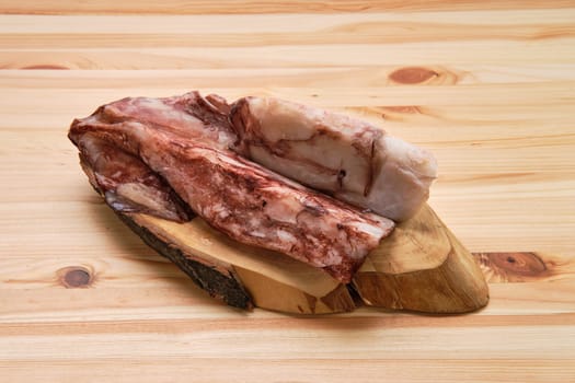 Frozen fresh octopus or squids raw on wooden board