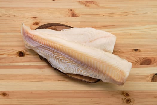 Frozen fillet of cod on wooden table