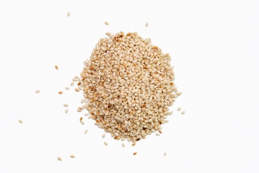 Top view of sesame seeds scattered on white paper