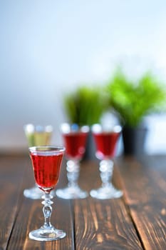 Vodka infused with berries on wooden background (photo with shallow depth of field)