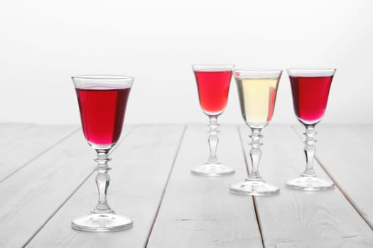 Vodka infused with berries on wooden background (photo with shallow depth of field)