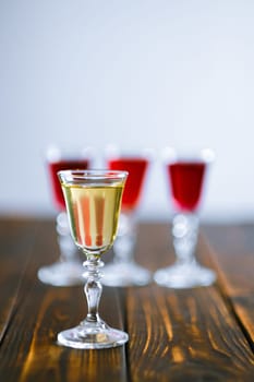 Vodka infused with berries on wooden background (photo with shallow depth of field)