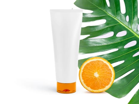 Luxury skin care product ad, top view of tube mock-ups with monstera leaf and oranges