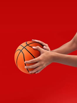 Hands and basketball isolated on red background