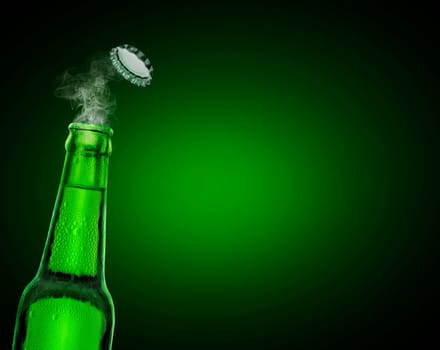 cold wet open beer bottle with smoke on green background