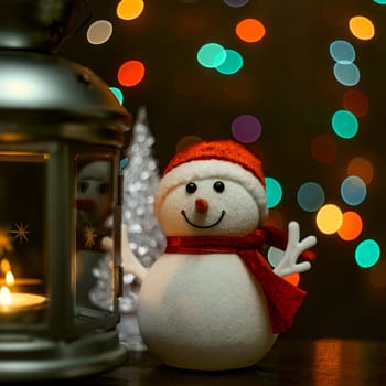 Christmas composition: a snowman, a lantern with candles and blurred bokeh lights in the background.