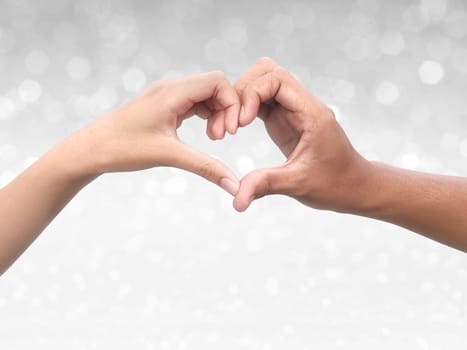Couple making heart shape with hand on shining bokeh background