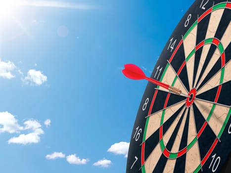 Darts with dartboard with blue sky background concept for hitting target, goal and success