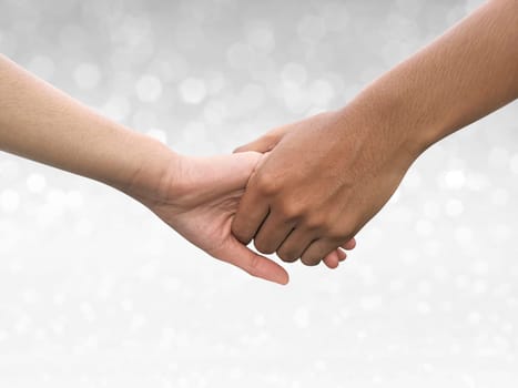Image of a couple holding hands on shining bokeh background