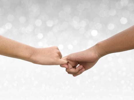 Image of a couple holding hands on shining bokeh background