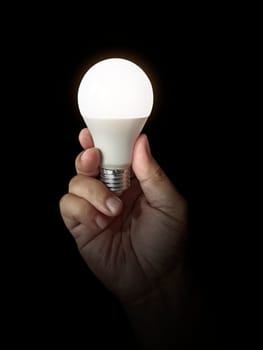 LED lamp in hand on black background
