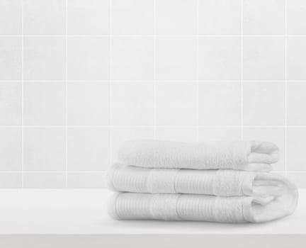 Stack of white clean towels on table in bathroom