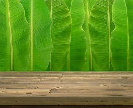 Wooden table with whole fresh banana leaves background
