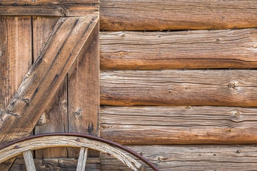 Abstract of Vintage Antique Log Cabin Wall and Wagon Wheel.