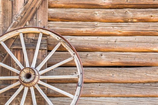 Abstract of Vintage Antique Log Cabin Wall and Wagon Wheel.