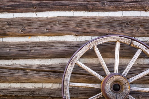 Abstract of Vintage Antique Log Cabin Wall and Wagon Wheel.