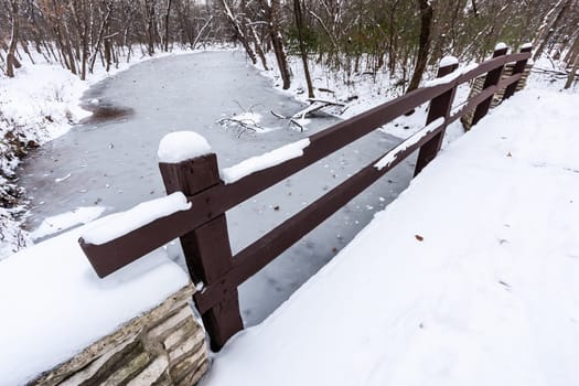 Rustic Bridge Over Frozen River In Winter.
