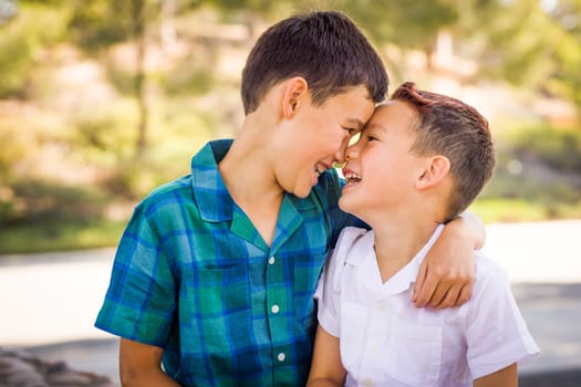 Outdoor portrait of biracial Chinese and Caucasian brothers having fun.