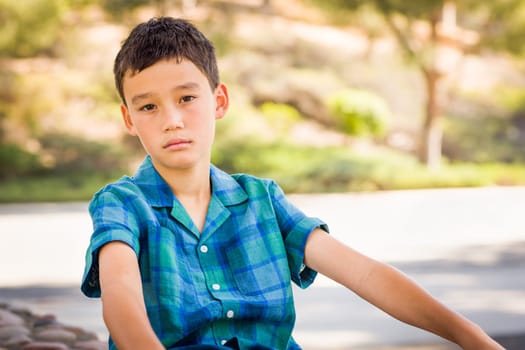 Outdoor portrait of a biracial Chinese and Caucasian boy.