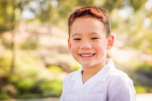 Outdoor portrait of a biracial Chinese and Caucasian boy.