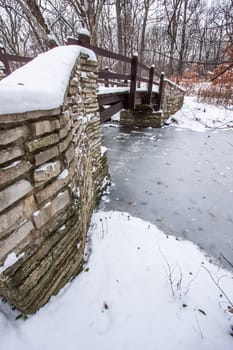 Rustic Bridge Over Frozen River In Winter.