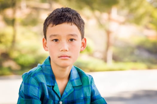 Outdoor portrait of a biracial Chinese and Caucasian boy.