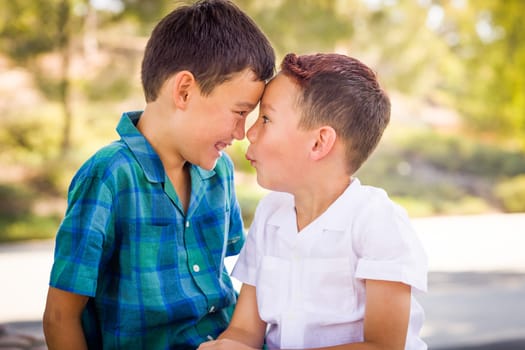 Outdoor portrait of biracial Chinese and Caucasian brothers having fun.
