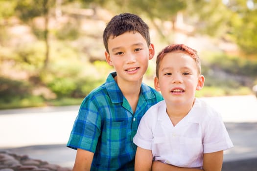 Outdoor portrait of biracial Chinese and Caucasian brothers.