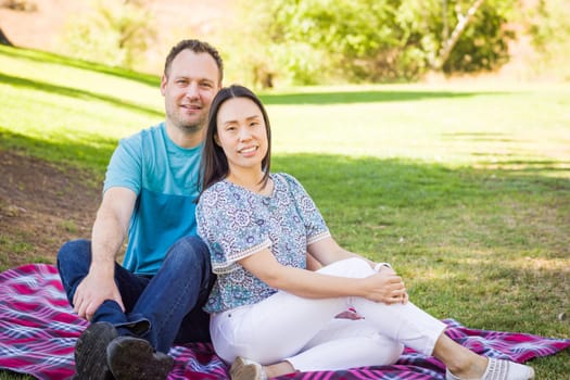 Outdoor portrait of biracial Chinese and Caucasian couple.