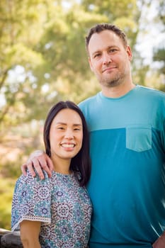 Outdoor portrait of biracial Chinese and Caucasian couple.