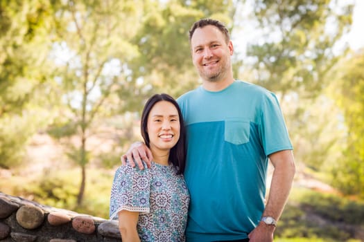 Outdoor portrait of biracial Chinese and Caucasian couple.