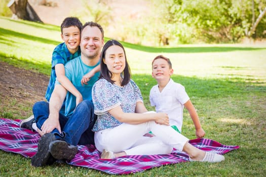 Outdoor portrait of biracial Chinese and Caucasian family.