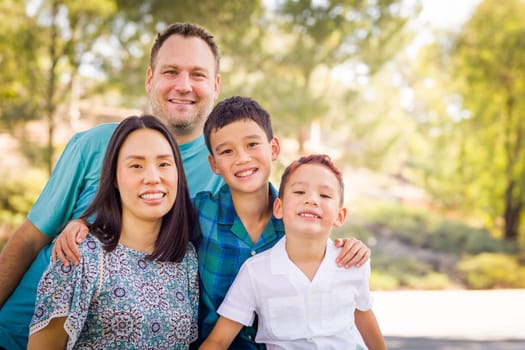 Outdoor portrait of biracial Chinese and Caucasian family.
